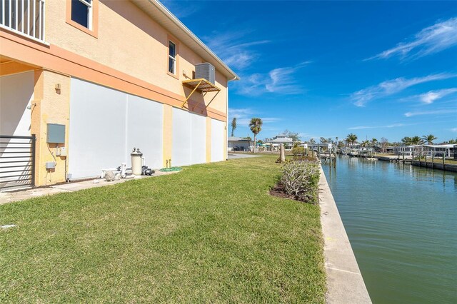 view of yard with a water view and a boat dock