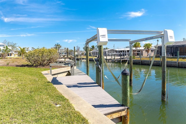 dock area with a lawn and a water view