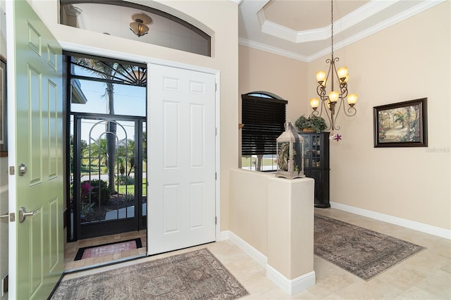 foyer entrance with plenty of natural light, ornamental molding, light tile patterned floors, and a notable chandelier