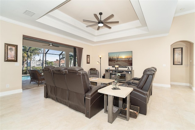 living room with crown molding, ceiling fan, and a tray ceiling