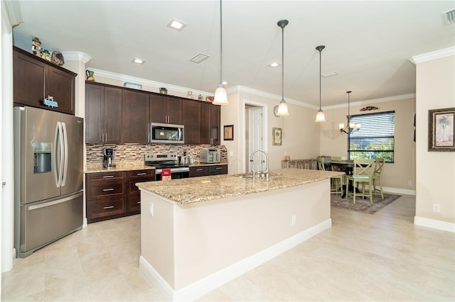 kitchen featuring dark brown cabinetry, sink, hanging light fixtures, appliances with stainless steel finishes, and a kitchen island with sink