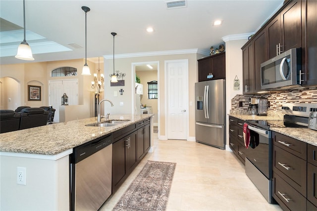 kitchen with sink, appliances with stainless steel finishes, hanging light fixtures, dark brown cabinetry, and a center island with sink