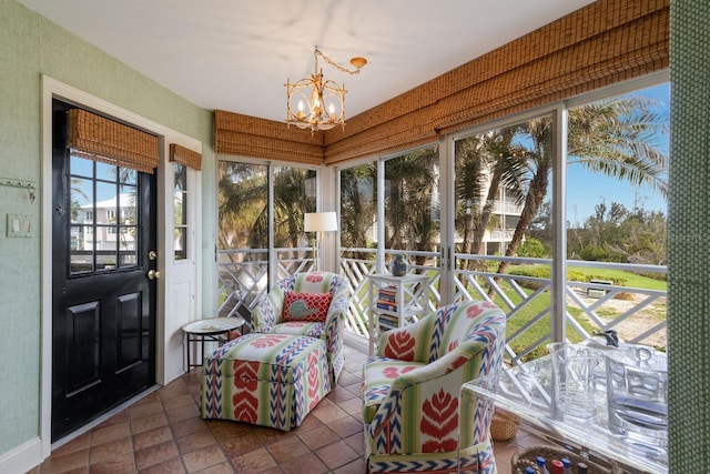 sunroom / solarium with a notable chandelier