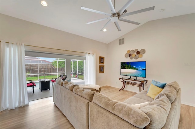 living room featuring ceiling fan, lofted ceiling, and light hardwood / wood-style floors