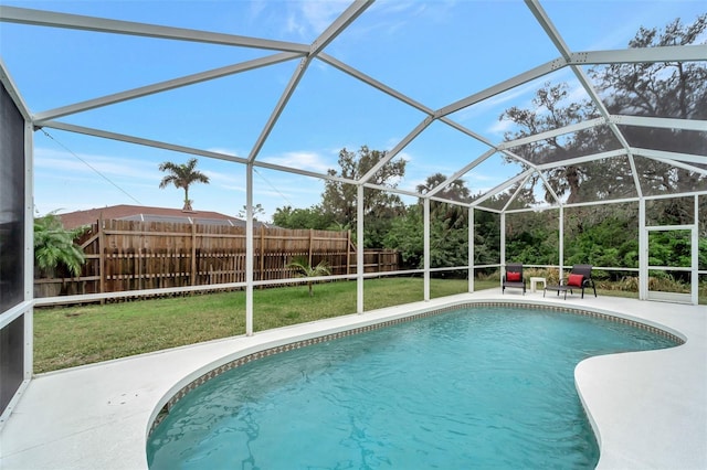 view of pool with a patio area, glass enclosure, and a lawn