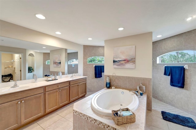 bathroom featuring vanity, independent shower and bath, tile patterned flooring, and tile walls