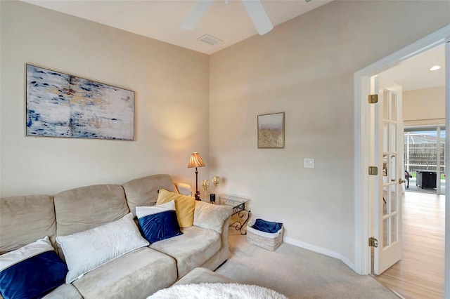 carpeted living room with ceiling fan