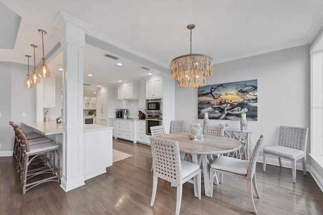 dining room with an inviting chandelier, dark hardwood / wood-style floors, and ornamental molding