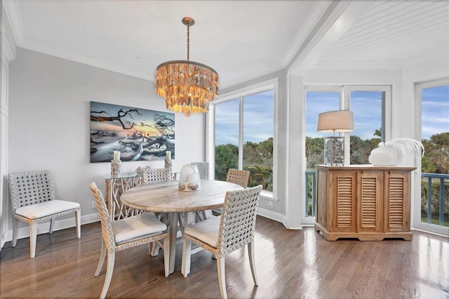 dining space featuring hardwood / wood-style floors, crown molding, and a chandelier