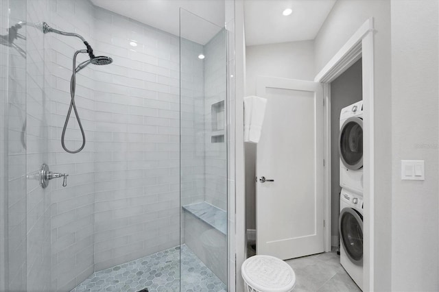 bathroom featuring tiled shower, tile patterned floors, and stacked washer / drying machine