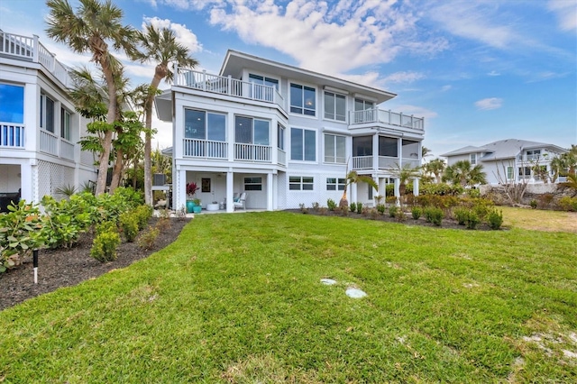 back of property with a balcony and a lawn