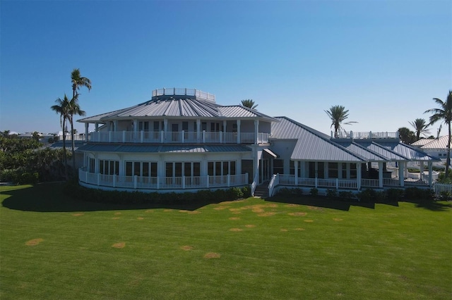 rear view of house with a balcony and a lawn