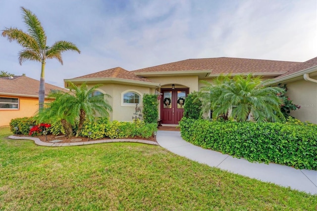 mediterranean / spanish home featuring french doors and a front lawn