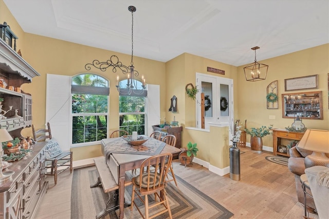 dining space with light wood-type flooring and an inviting chandelier