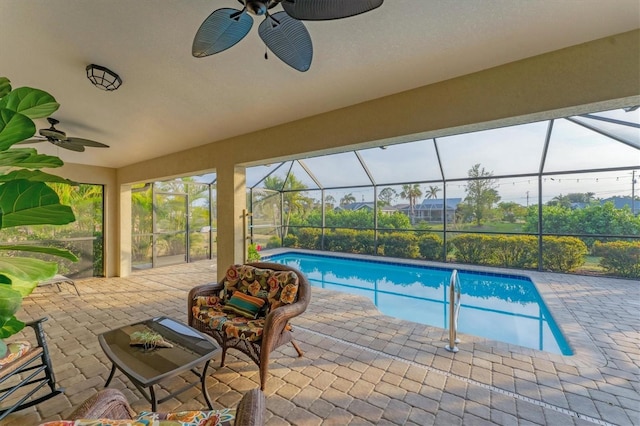 view of pool with ceiling fan, a patio, and glass enclosure