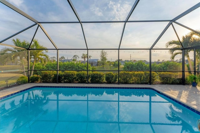 view of swimming pool featuring a patio area and glass enclosure