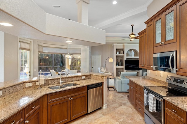 kitchen with a sink, stainless steel appliances, brown cabinetry, and hanging light fixtures