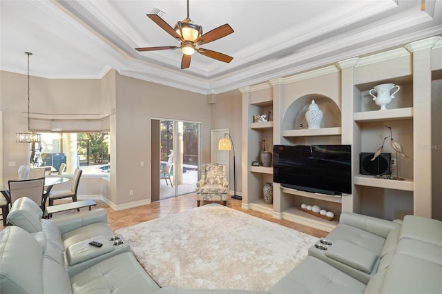 tiled living room featuring crown molding, built in features, ceiling fan, and a tray ceiling