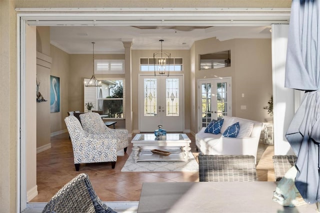 sitting room featuring tile patterned flooring, an inviting chandelier, ornamental molding, french doors, and ornate columns