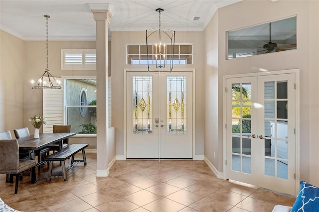 tiled foyer entrance with french doors, plenty of natural light, and a chandelier