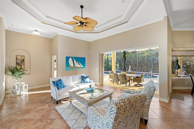 living room with a raised ceiling, crown molding, and ceiling fan