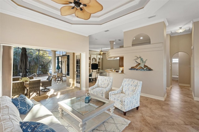 tiled living room featuring crown molding, ceiling fan, and a tray ceiling