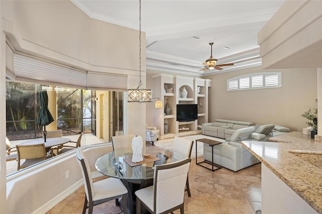 dining room with crown molding, plenty of natural light, ceiling fan, and a tray ceiling