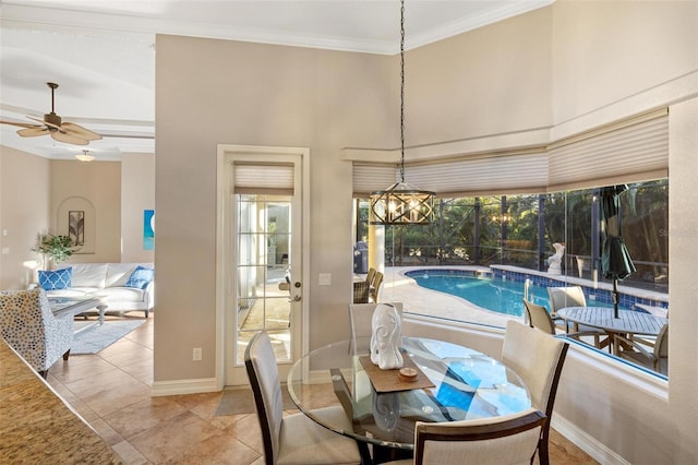 dining room featuring plenty of natural light, crown molding, ceiling fan, and a towering ceiling