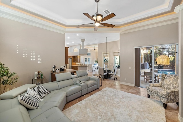 tiled living room featuring crown molding, ceiling fan, and a tray ceiling