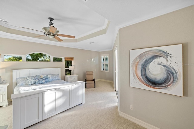 carpeted bedroom featuring ornamental molding, ceiling fan, and a tray ceiling