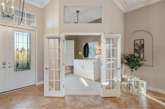 foyer featuring french doors, light colored carpet, and crown molding