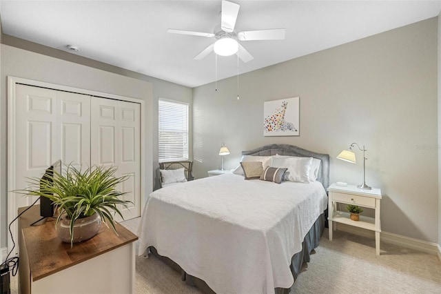 carpeted bedroom featuring ceiling fan and a closet