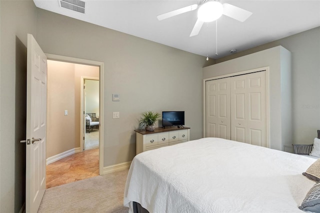 bedroom featuring visible vents, light carpet, a ceiling fan, a closet, and baseboards