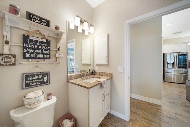 bathroom featuring hardwood / wood-style flooring, vanity, and toilet