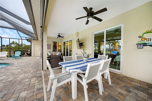 view of patio featuring outdoor lounge area, ceiling fan, and glass enclosure