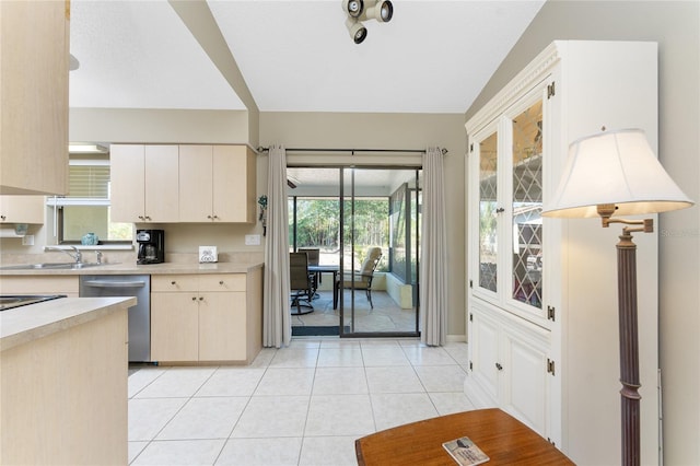 kitchen featuring a wealth of natural light, dishwasher, sink, and light tile patterned floors