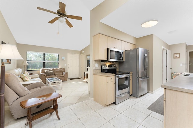 kitchen featuring light tile patterned flooring, ceiling fan, stainless steel appliances, decorative backsplash, and cream cabinetry