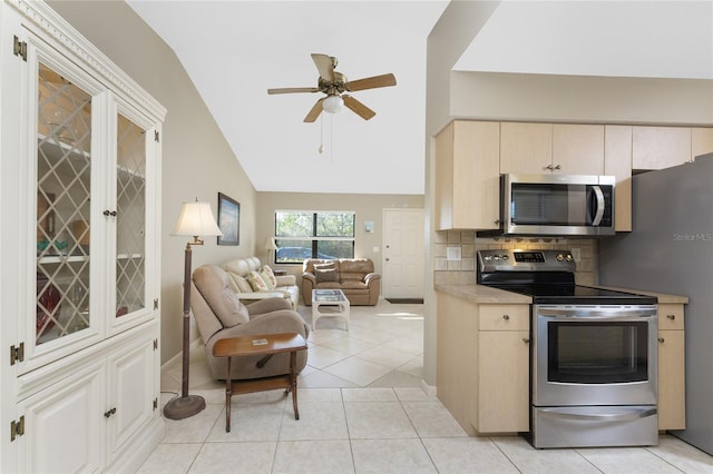 kitchen featuring lofted ceiling, tasteful backsplash, light tile patterned floors, appliances with stainless steel finishes, and ceiling fan