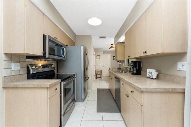 kitchen with tasteful backsplash, light tile patterned flooring, light brown cabinets, and appliances with stainless steel finishes