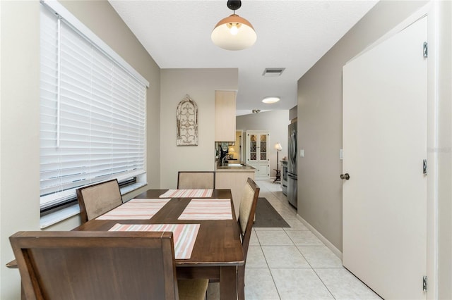 tiled dining space featuring sink and a textured ceiling