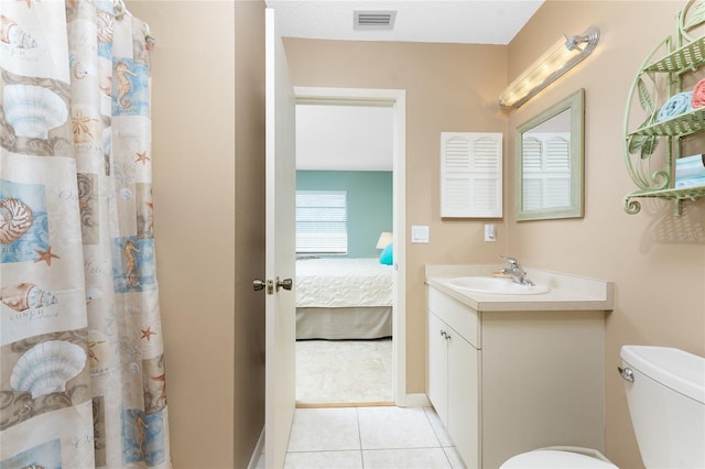 bathroom featuring tile patterned flooring, vanity, and toilet