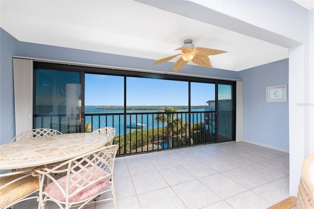 sunroom / solarium featuring a water view and ceiling fan