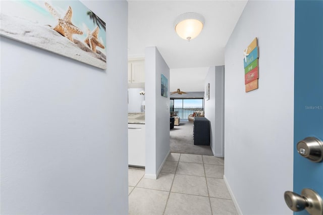 hallway featuring baseboards and light tile patterned floors