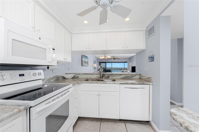 kitchen with white appliances, white cabinets, and a sink