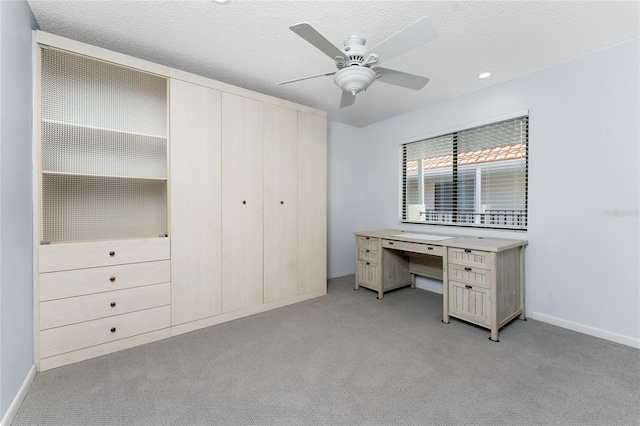 unfurnished bedroom with a ceiling fan, light colored carpet, a textured ceiling, and baseboards