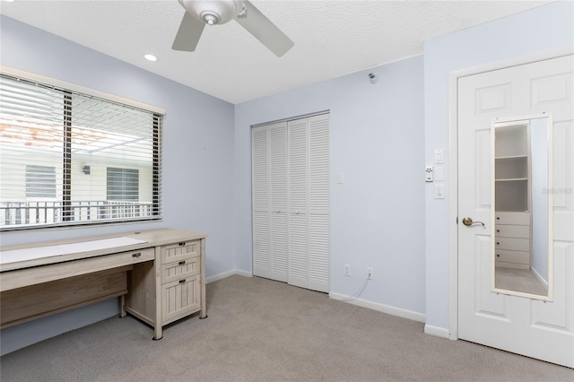 office area with light carpet, a textured ceiling, and baseboards