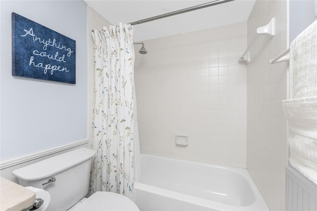 full bathroom featuring toilet, a wainscoted wall, and shower / bathtub combination with curtain