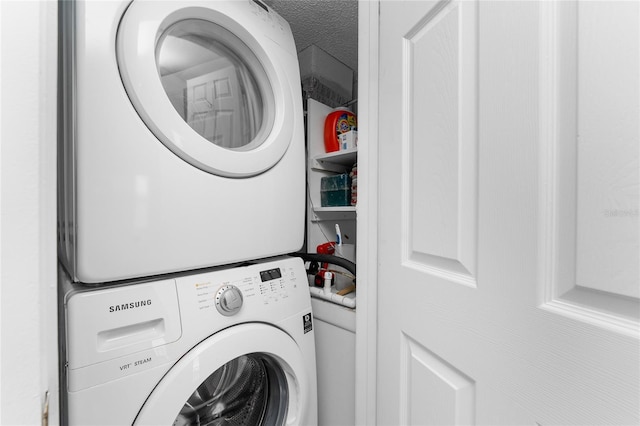 washroom with laundry area, stacked washing maching and dryer, and a textured ceiling