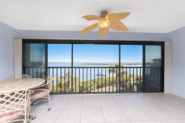 unfurnished sunroom featuring ceiling fan and a water view