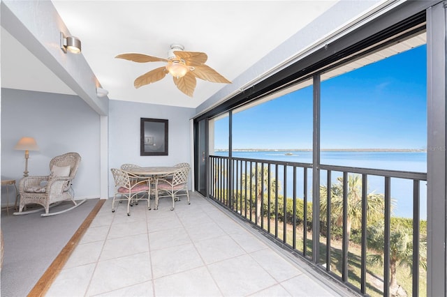 sunroom with a water view and ceiling fan